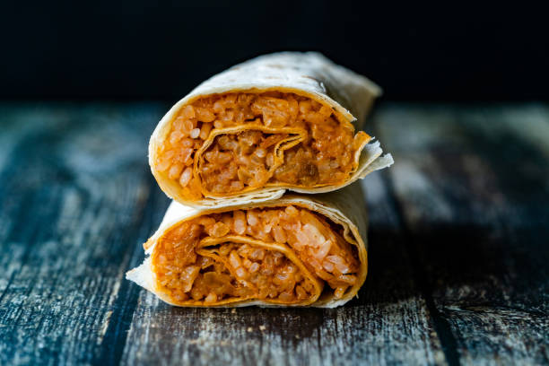 A burrito cut in half and stacked to show rice, beans and filling