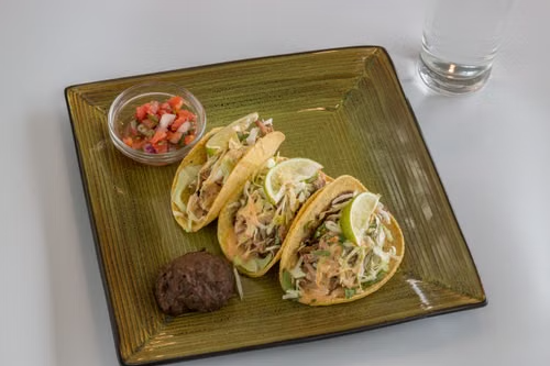 Chicken tacos topped with crunchy cabbage and pico de gallo